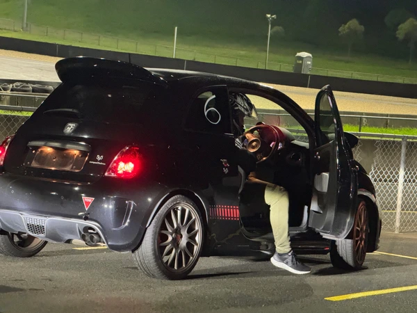 Club members inspecting the custom 16-valve engine bay of a modified Fiat X1/9